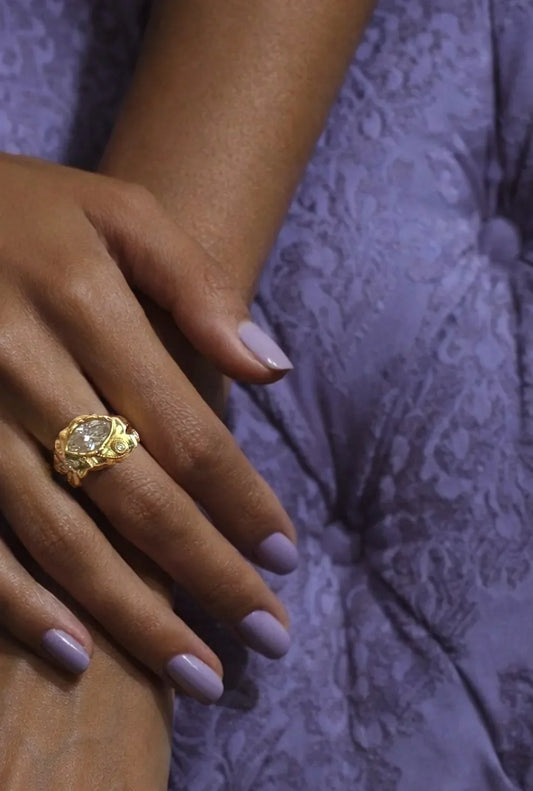 Gold marquise diamond commission worn on hand against lavender silk, a custom pendants and rings house