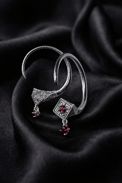 White gold Tuareg hoops with ruby drops on satin, evil eye talisman protection form