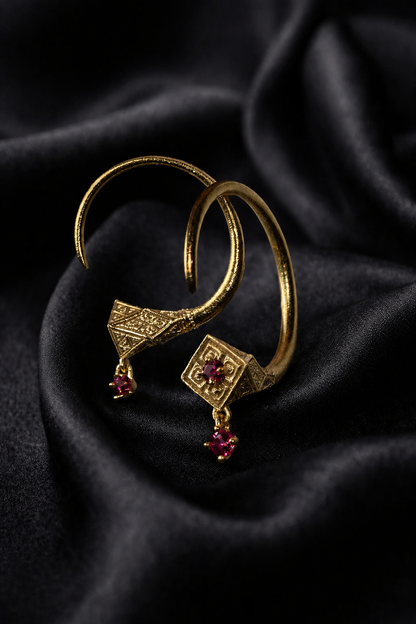 Gold Tuareg hoops with ruby drops, pointed talisman silhouette in 18k