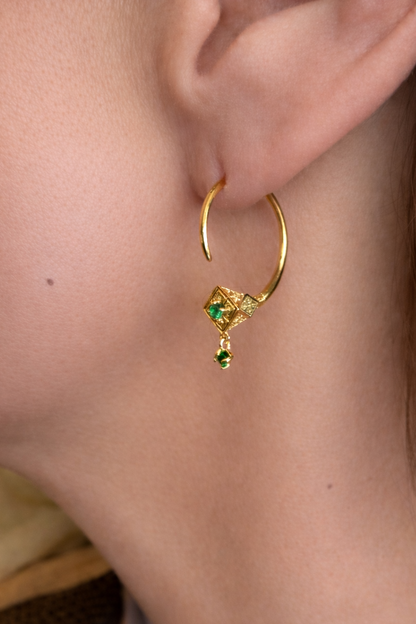 Gold Tuareg hoop with emerald drop worn on ear, a pointed amulet for evil eye
