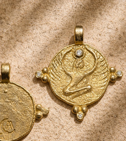 Gold winged goddess disc with diamond crown on sandstone, one of Egypt's protection amulets