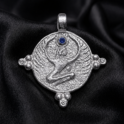 Egyptian goddess isis wings metal relief in white gold, blue sapphire crown stone on silk