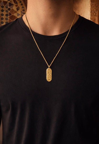 Gold Bereka pendant worn by man in black tee, African jewelry for men with Amharic script