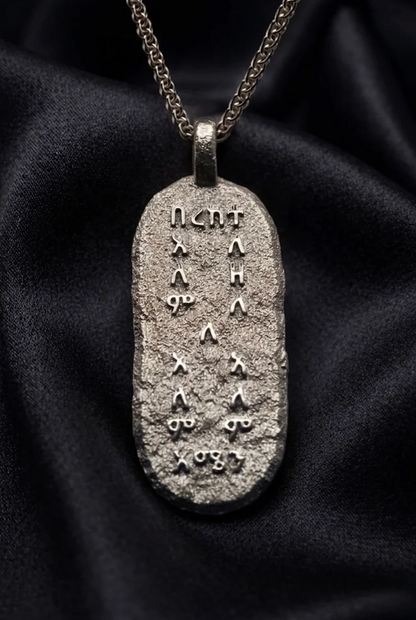 White gold Bereka pendant, rough cast Amharic prayer tablet on dark satin, amulet necklace