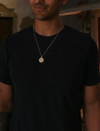 Man wearing the white gold shield pendant on box chain, African male jewelry in black tee