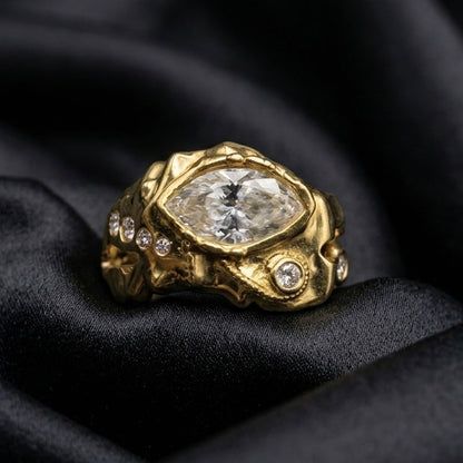 Marquise diamond ring in sculpted 18k gold, bezel set diamonds along the band on black silk