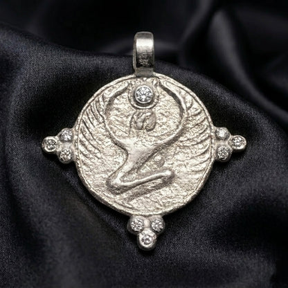 White gold winged Isis disc with diamond crown stone, goddess jewelry on dark satin
