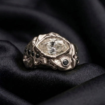 White gold marquise ring with black diamond accents, a non traditional engagement ring on satin