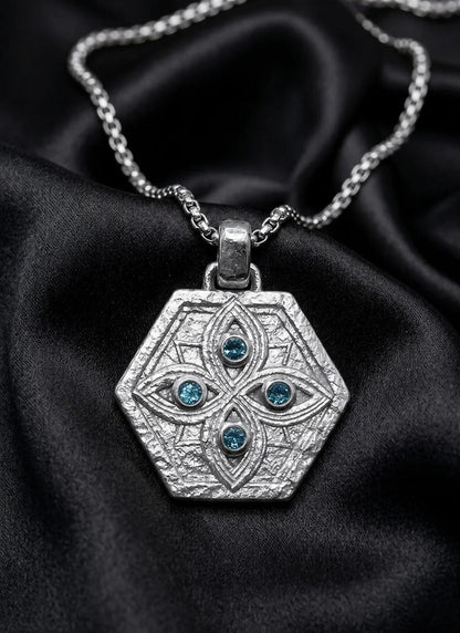 White gold shield pendant with blue sapphire watchers, guardian eyes in sculpted relief