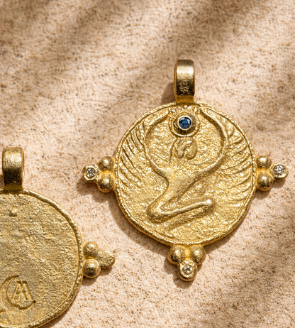 Gold Egyptian goddess sculpture in miniature, blue sapphire crown stone, disc on sandstone