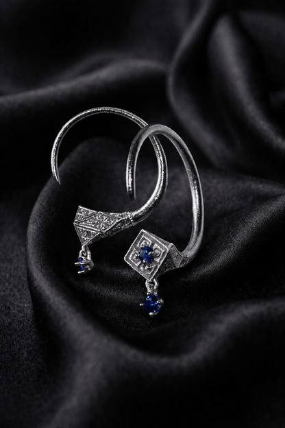 White gold Tuareg hoops with blue sapphire drops, an evil eye protection charm pair