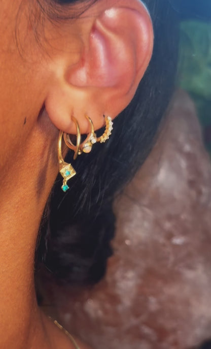 Video of the gold Tuareg hoop with emerald drop in a layered ear stack, evil eye for protection