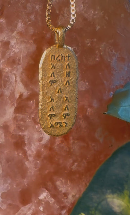 Video of the gold Bereka pendant on rose stone, boho necklace with hand raised lettering