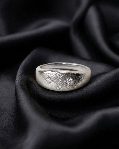 White gold Meskel ring set with five prong set diamonds, lattice face in worked texture